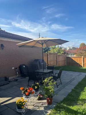 a patio with a table and an umbrella at Home in Scarborough, near GO station, TTC and UoT in Toronto