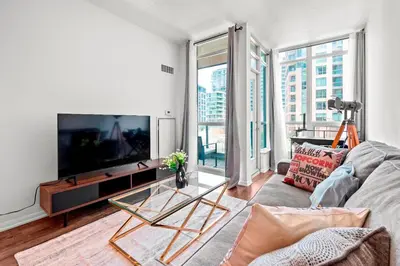 a living room with a large flat screen tv at 1 Bedroom Condo with Balcony Fort York Downtown Toronto in Toronto