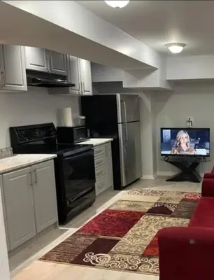 a kitchen with a tv in the middle of it at Peace Apartment in Brampton