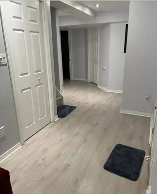 an empty room with a door and wooden floors at Peace Apartment in Brampton