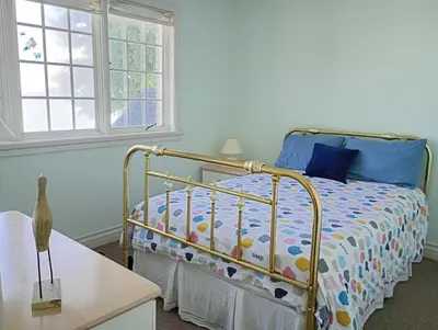 a bedroom with a bed and a table at Lakeside Villa across Whisky Run Golf Club in Port Colborne