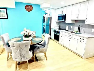 a kitchen with a table and chairs and a blue wall at Modern 2BR suite Kitchen Workspace Laundry in London