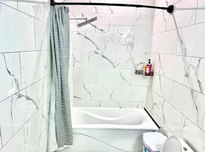 a white bathroom with a tub and a shower at Private Room In Cambridge B13 in Cambridge