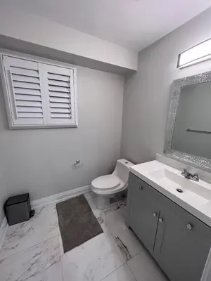 a bathroom with a toilet and a sink and a window at Beautiful Lake Side Neighbourhood Home in Ajax, ON in Ajax