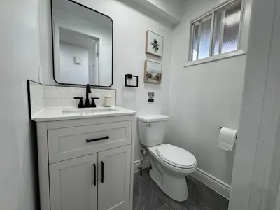 a white bathroom with a toilet and a mirror at North Barrie !A Stylish and Spacious Private Bedroom with Private Bathroom in Barrie