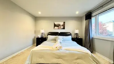 a bedroom with a large bed and a window at Designer 4BR Retreat, Luxe Living & Family-Friendly Fun in Mississauga