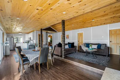 a dining room and living room with a wooden ceiling at Rustic Lakefront Cottage with Fire Pit & Scenic Views in Brechin
