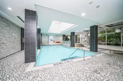a large swimming pool in the middle of a building at PlanURstay - Ideal 2BR & 2 BTH - Near SQ1 Mall in Mississauga