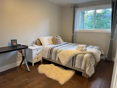 a bedroom with a bed and a desk and a window at Quite room finch birchmunt in Toronto