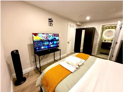 a bedroom with a bed and a flat screen tv at 1-Bedroom 1Bathroom Entire Unit closer to Fairview Mall & Waterloo Airport in Kitchener