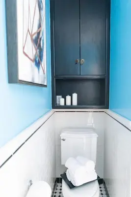a bathroom with a toilet and a black cabinet at New York Style Brownstone Elegant Home in Toronto's Vibrant King West in Toronto