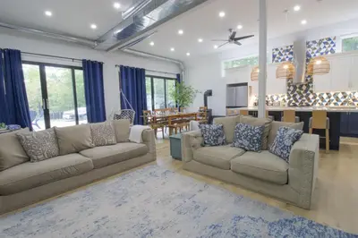 a living room with two couches and a kitchen at Spacious 4 Bdrm, Lake Views, Steps from the Beach in Tiny