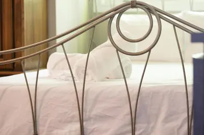 a metal bed with white sheets and pink sheets at Spacious 4 Bdrm, Lake Views, Steps from the Beach in Tiny