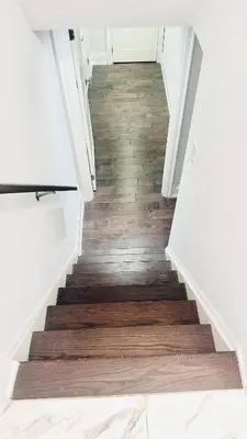 a staircase with wood flooring in a house at Bright 2 Bed Basement Near Square One Mall Family Friendly Stay in Mississauga