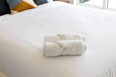 two towels sitting on top of a white bed at Spacious 3BR Loft with Balcony and Free Parking in Toronto