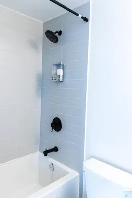 a bathroom with a white tub and a toilet at Spacious 3BR Loft with Balcony and Free Parking in Toronto