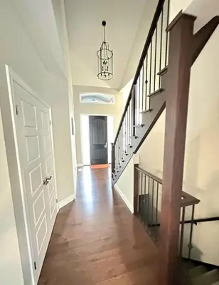 a hallway with a white door and a stair case at Fieldstone Estate in Tillsonburg