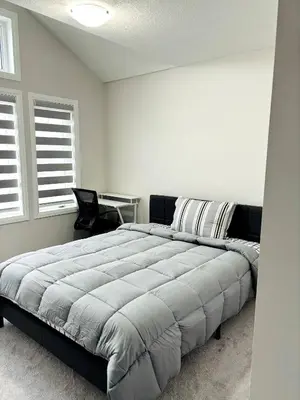 a bedroom with a large bed and a desk at Cozy Private Room with ensuite in Shared Home in Ayr in Paris