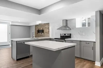 a white kitchen with a large white counter top at Bright & Cozy Basement Retreat in Oshawa