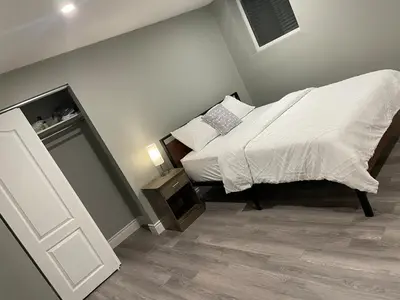 a small bedroom with a bed and a night stand at Bright & Cozy Basement Retreat in Oshawa