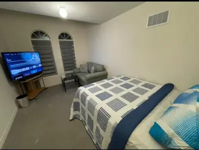 a bedroom with a bed and a flat screen tv at Budget Friendly Home in Oshawa