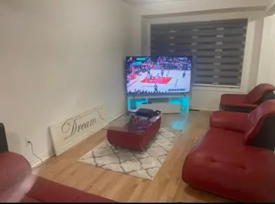 a living room with a flat screen tv and red furniture at Budget Friendly Home in Oshawa