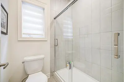 a bathroom with a toilet and a glass shower at Very Modern New Luxury House in RichmondHill in Richmond Hill