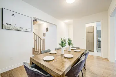 a dining room with a wooden table and chairs at Very Modern New Luxury House in RichmondHill in Richmond Hill