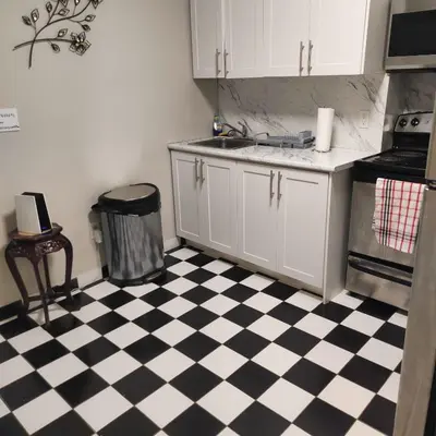 a kitchen with a black and white checkered floor at Affordable Toronto Downtown Bloor Stay in Toronto
