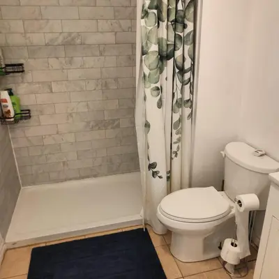 a bathroom with a toilet and a shower curtain at Affordable Toronto Downtown Bloor Stay in Toronto