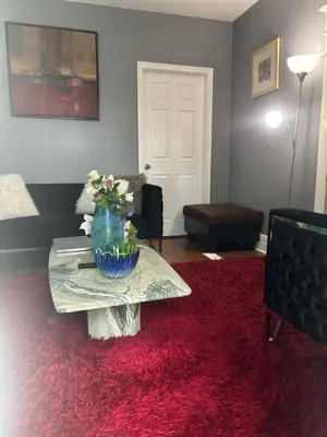 a living room with a table with a red rug at Woodbridge Heritage Home in Vaughan