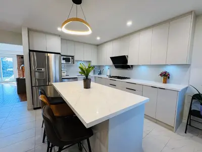 a kitchen with white cabinets and a white counter top at Modern Newly-Renovated Suite Free Parking in Toronto