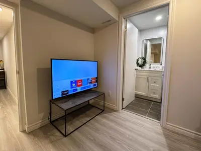 a living room with a flat screen tv on a table at Modern Newly-Renovated Suite Free Parking in Toronto