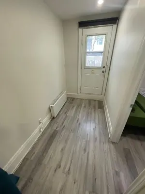 an empty room with a door and wooden floors at Exclusive Queen St Downtown Full House-PRIVATE PATIO in Toronto