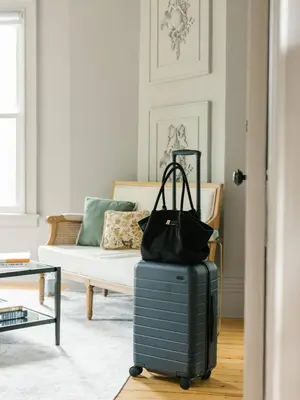 a suitcase sitting in a living room with a couch at Guestroom in Old Town | Steps to Lake & Everything in Niagara on the Lake