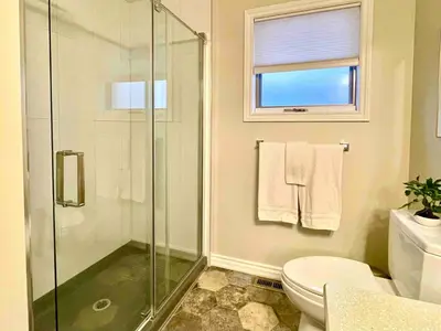 a bathroom with a shower and a toilet and a window at Top 1% Quiet Private Guestroom 2ppl Old Town NOTL in Niagara on the Lake