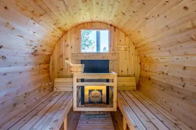 a log cabin with a fireplace in the middle at Top 5% Sauna | Bocce Ball | Vineyard Views | NOTL in Niagara on the Lake