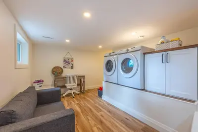 a living room with a washer and dryer at Top 5% Sauna | Bocce Ball | Vineyard Views | NOTL in Niagara on the Lake