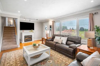 a living room with a leather couch and a fireplace at Vineyard Home Pet Friendly NOTL Large Backyard in Niagara on the Lake