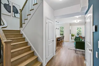 a hallway with stairs leading to a dining room at 2 Brdm Modern Brand New Niagara Apt up to 6 ppl in Niagara on the Lake