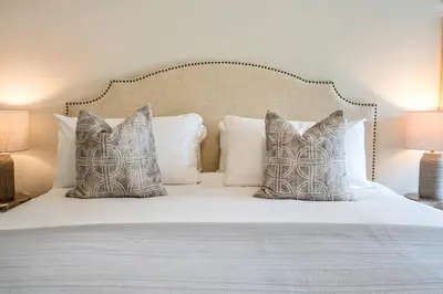 a bedroom with a white bed with pillows at 2 Brdm Modern Brand New Niagara Apt up to 6 ppl in Niagara on the Lake