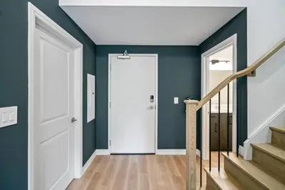 a hallway with blue walls and a white door at 2 Brdm Modern Brand New Niagara Apt up to 6 ppl in Niagara on the Lake