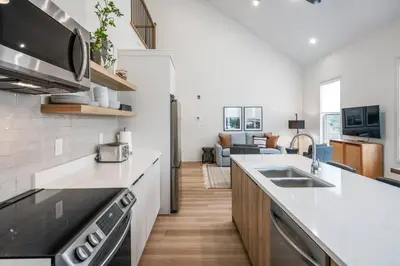 a kitchen with a counter top and a living room at 2 Bdrm New Stylish Apt for up to 6 ppl in Niagara in Niagara on the Lake
