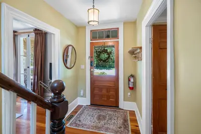 a hallway with a wooden door with a rug at Hot Tub | Mini Putt | Historic Old Town | 2 Guests in Niagara on the Lake