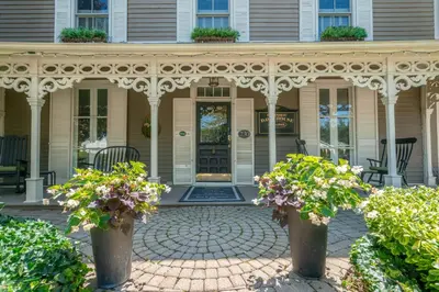 a porch of a house with two potted plants at Hot Tub | Heart of Old Town NOTL | 2 Guests in Niagara on the Lake