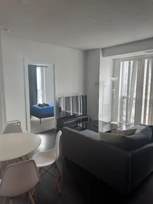 a living room with a couch and a table at Lush 3 Bedroom Condo by CN Tower - Free Parking in Toronto