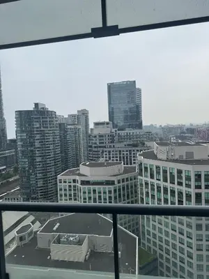 a view of a city skyline from a window at Lush 3 Bedroom Condo by CN Tower - Free Parking in Toronto