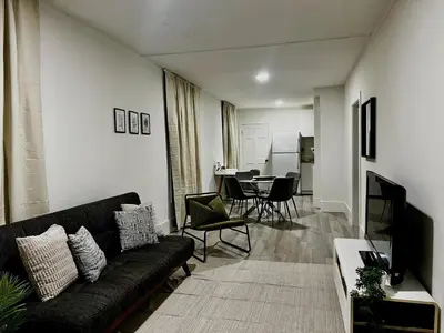 a living room with a black couch and a table at Etobicoke Escape in Toronto