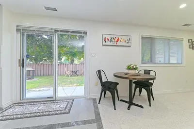 a dining room with a table and chairs and a window at SPACIOUS & FULLY PVT-2BR UNIT ON GROUND LEVEl in Burlington