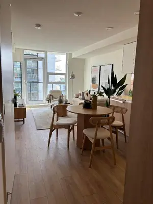 a kitchen and living room with a table and chairs at Deluxe Suites Downtown Toronto in Toronto